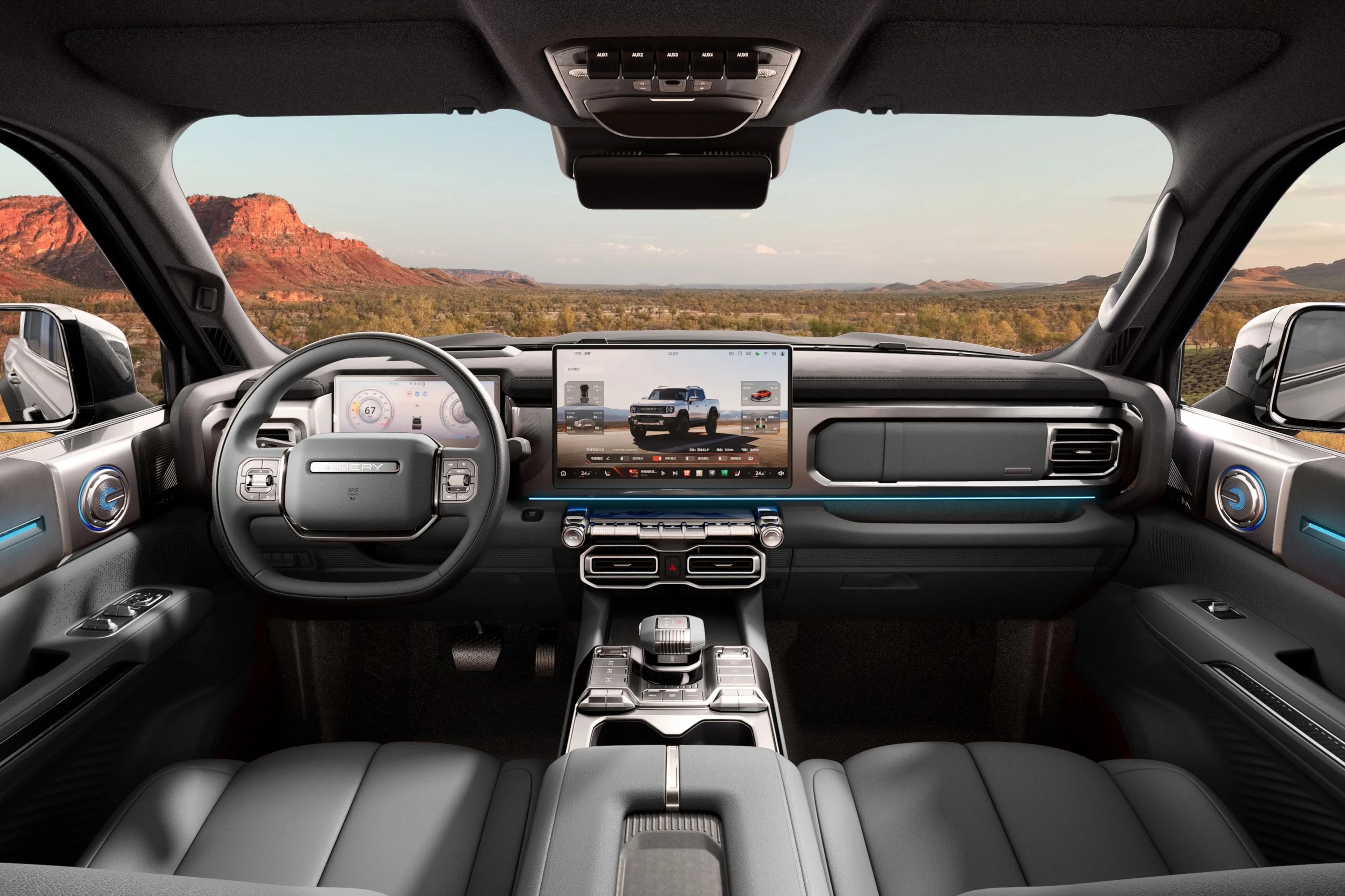 Interior de um carro moderno com painel escuro e detalhes em azul claro, volante multifuncional, tela central exibindo uma picape branca e um cen&aacute;rio des&eacute;rtico com montanhas avermelhadas ao fundo