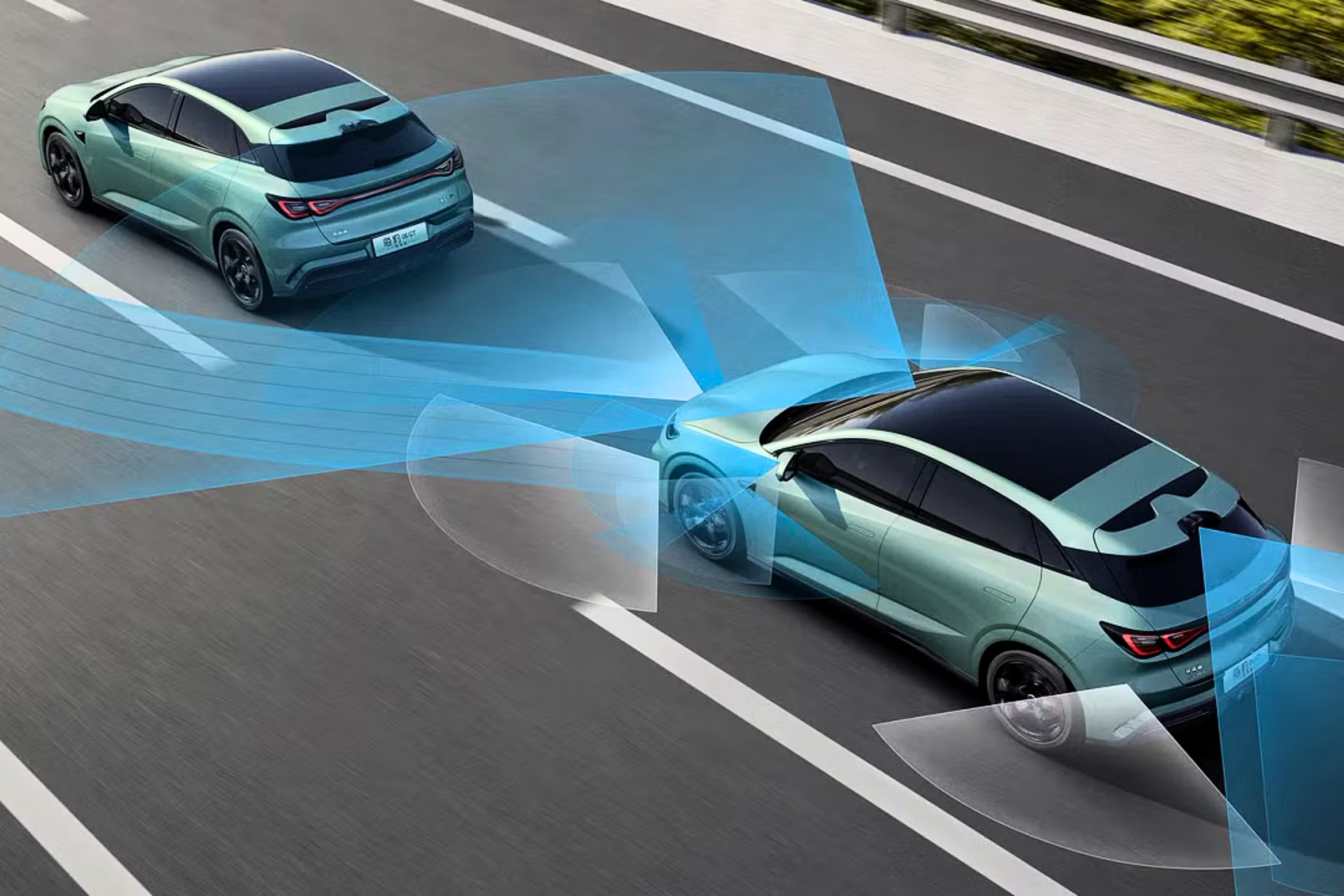 Dois carros verdes-&aacute;gua com teto preto em uma estrada, com feixes de luz azul simulando sensores de proximidade e assist&ecirc;ncia ao motorista