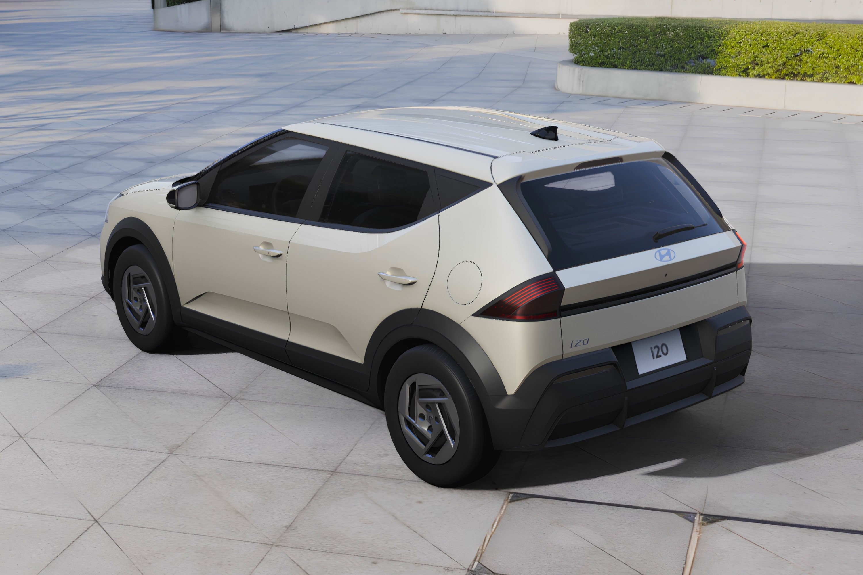 Carro Hyundai i20 bege claro, visto de cima e traseira, estacionado em piso de concreto com blocos quadrados. O ve&iacute;culo tem detalhes em preto fosco nas caixas de roda e para-choque traseiro, e rodas de liga leve cinza escuro. Ao fundo, um canteiro com arbustos verdes e uma constru&ccedil;&atilde;o moderna.