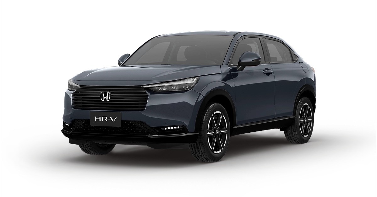SUV Honda HR-V 2023 cinza escuro, visto de frente e levemente de lado, com far&oacute;is acesos e grade frontal preta, sobre fundo branco