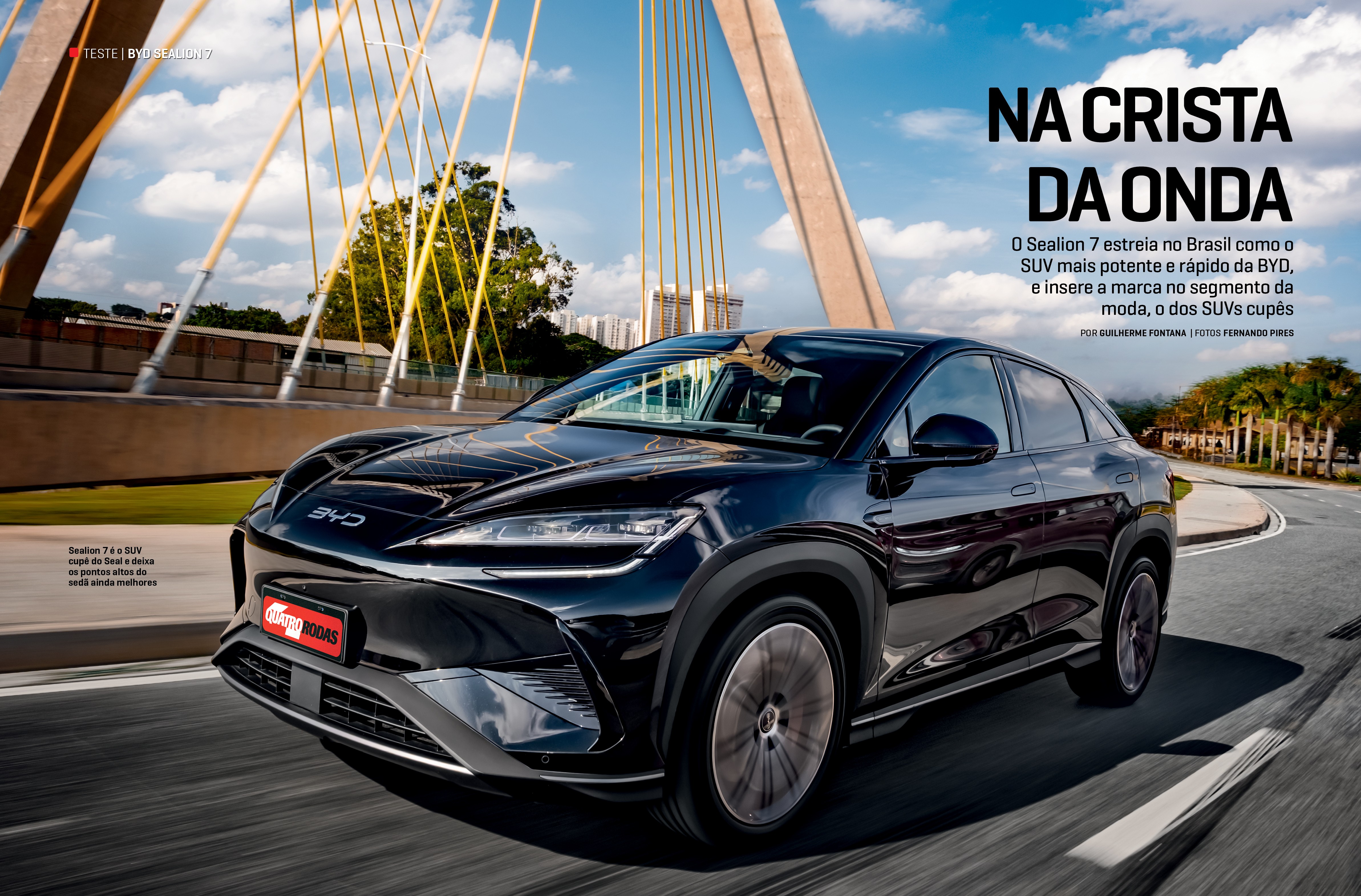 Um SUV cup&ecirc; preto brilhante, o BYD Sealion 7, em movimento numa estrada, com o logotipo BYD no cap&ocirc;. Ao fundo, um c&eacute;u azul com nuvens brancas e a estrutura de um viaduto estaiado com cabos amarelos. &Agrave; direita, &aacute;rvores e edif&iacute;cios distantes. A imagem transmite velocidade e modernidade