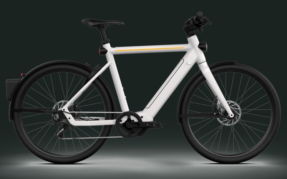 Bicicleta el&eacute;trica branca com detalhes em amarelo no quadro, guid&atilde;o preto, selim preto e pneus pretos, vista lateralmente sobre fundo escuro