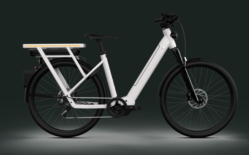 Bicicleta el&eacute;trica branca com quadro moderno, bateria preta no bagageiro traseiro e luz amarela. Possui pneus pretos, para-lamas e freios a disco, em fundo cinza escuro