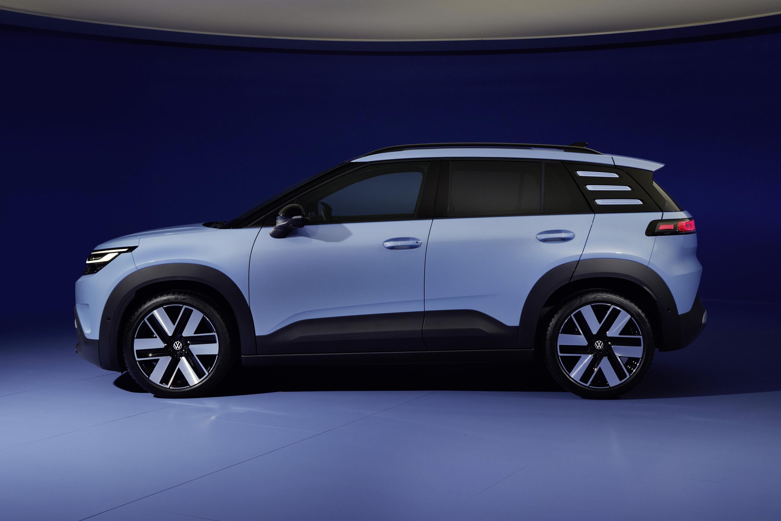 SUV compacto azul claro, visto de perfil, com detalhes em preto fosco nas caixas de roda e na parte inferior da carroceria. As rodas t&ecirc;m design moderno em preto e prata, e o carro est&aacute; em um est&uacute;dio com fundo azul escuro e piso azul claro.