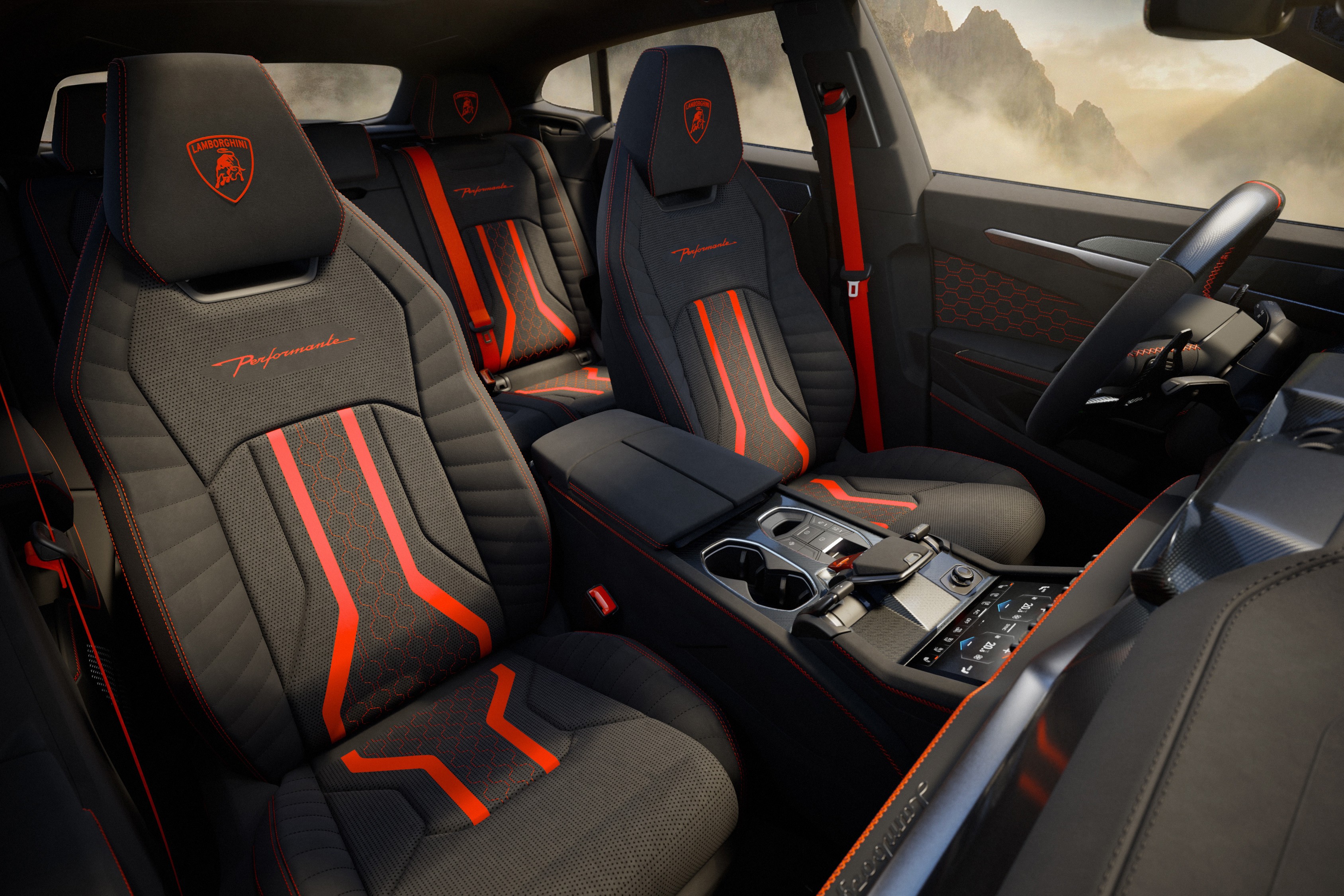 Interior de carro esportivo com bancos pretos e detalhes em vermelho, incluindo o logo da Lamborghini nos encostos de cabe&ccedil;a. O cinto de seguran&ccedil;a &eacute; vermelho, e o painel central possui porta-copos e controles digitais. Ao fundo, montanhas nebulosas s&atilde;o vis&iacute;veis pela janela