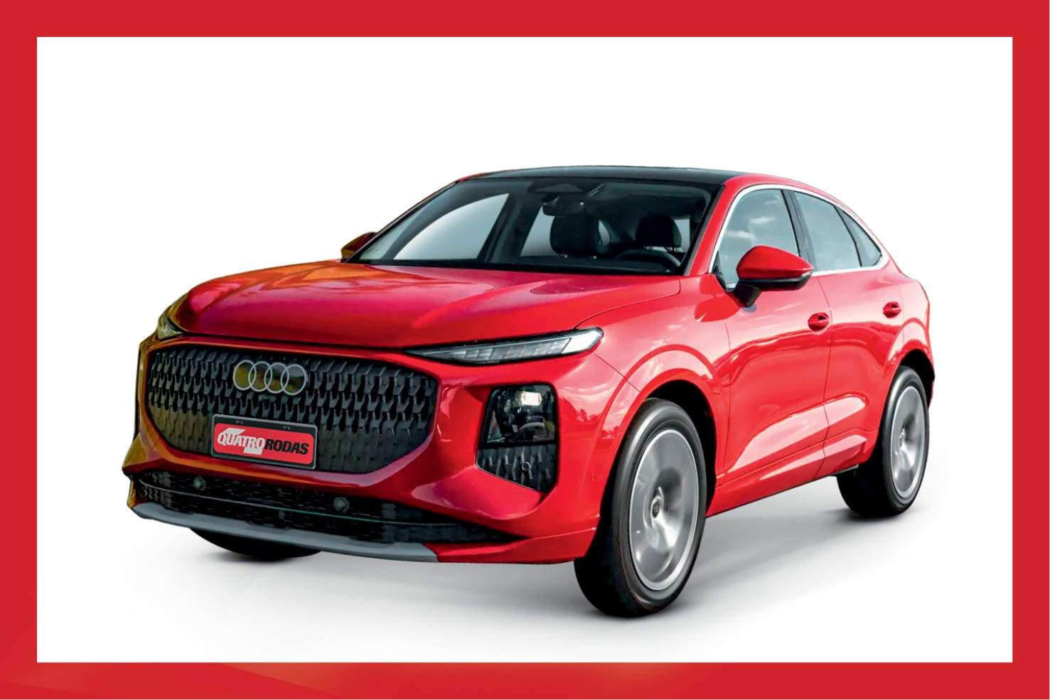 Carro Audi Q4 e-tron Sportback vermelho, com teto preto, parado em &acirc;ngulo frontal-lateral, sobre fundo branco. A grade frontal preta tem o logo da Audi e uma placa vermelha com o texto QUATRO RODAS em branco. As rodas prateadas com calotas cinzas est&atilde;o levemente borradas, sugerindo movimento