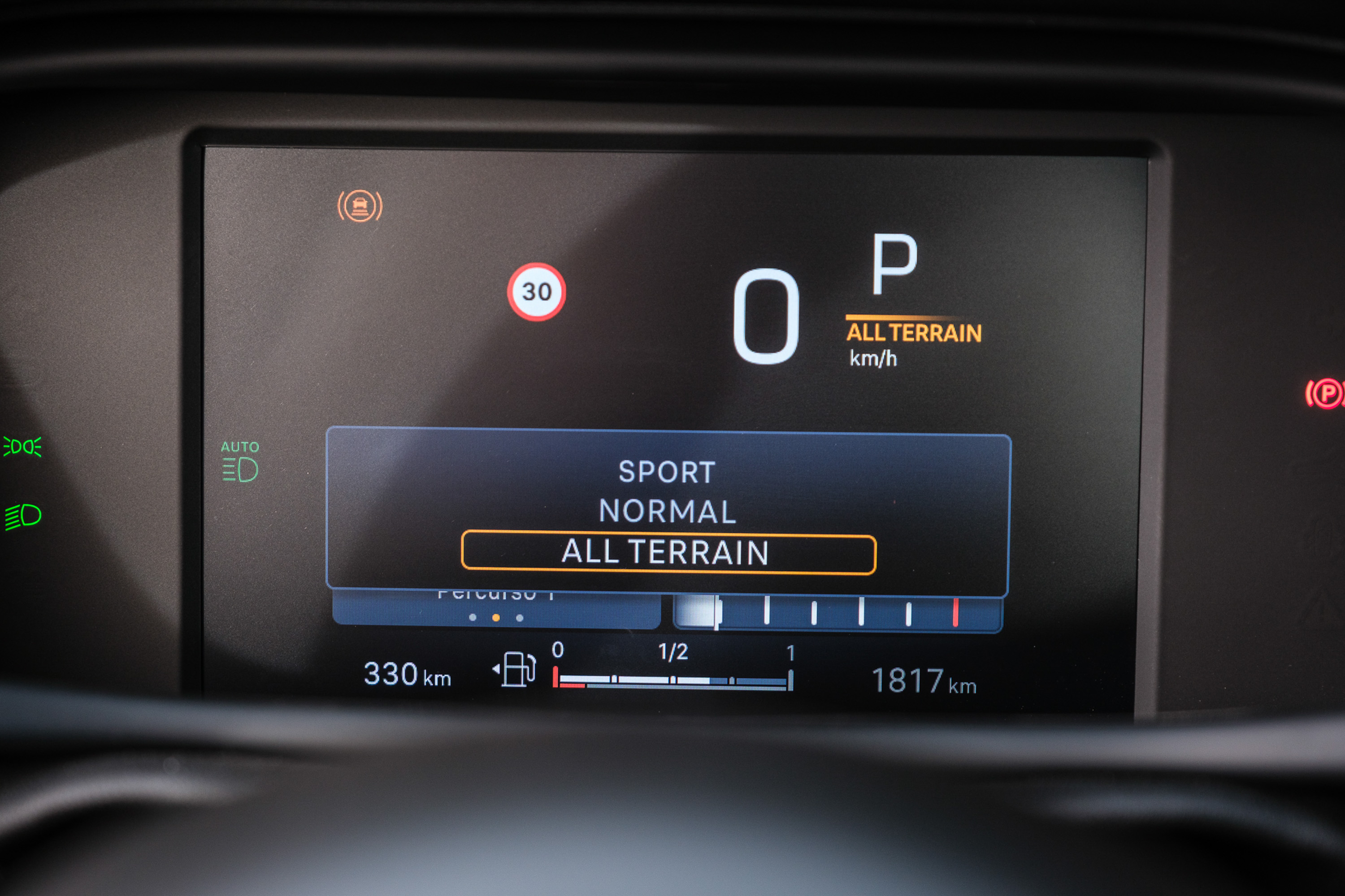 Painel digital de carro com modo ALL TERRAIN selecionado, velocidade 0 km/h, marcha P, limite de 30 km/h, far&oacute;is autom&aacute;ticos acesos, autonomia de 330 km e hod&ocirc;metro de 1817 km