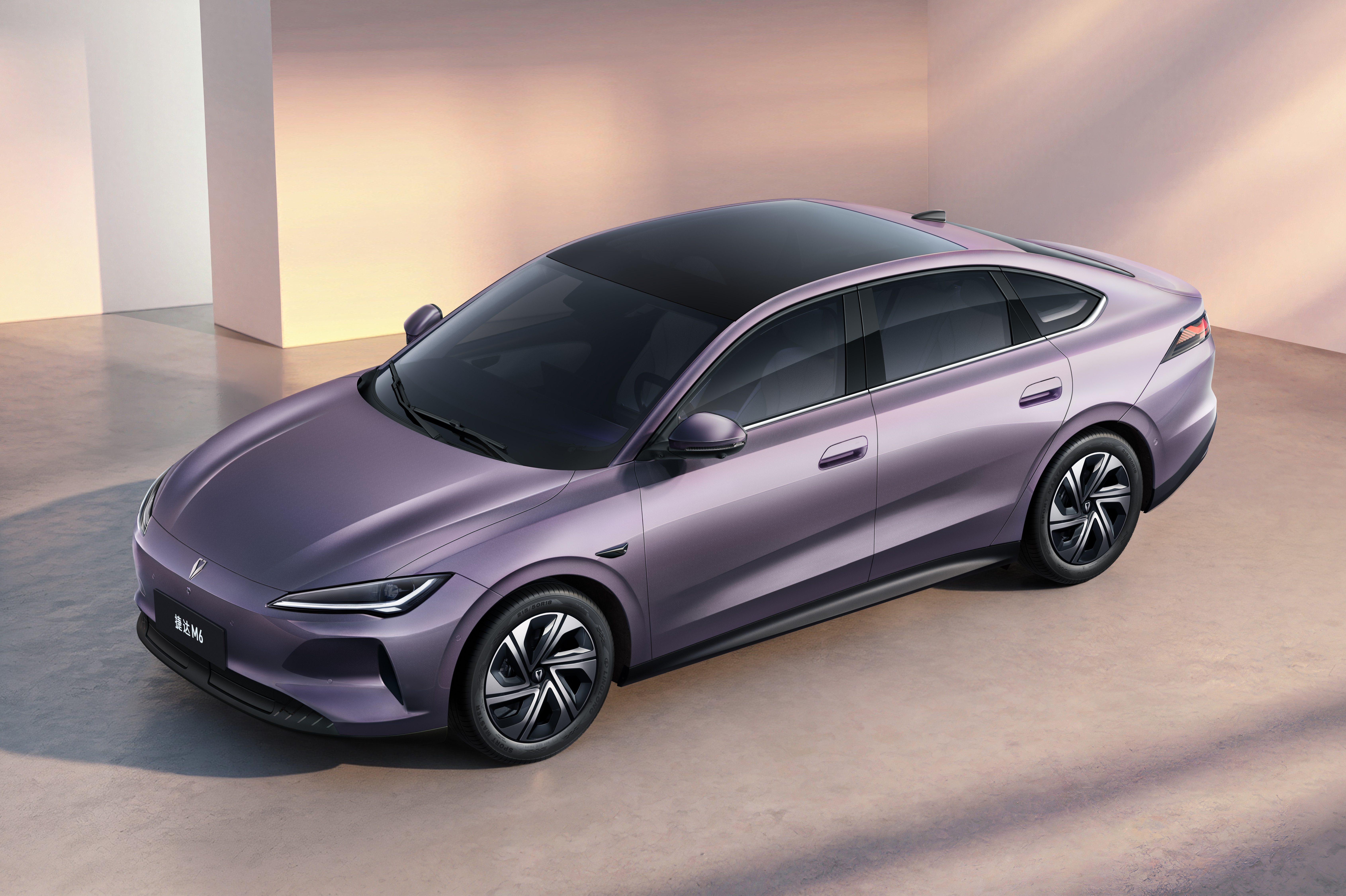 Carro sedan el&eacute;trico roxo com teto preto brilhante, rodas escuras e design moderno, estacionado em um ambiente minimalista com paredes claras e ilumina&ccedil;&atilde;o suave