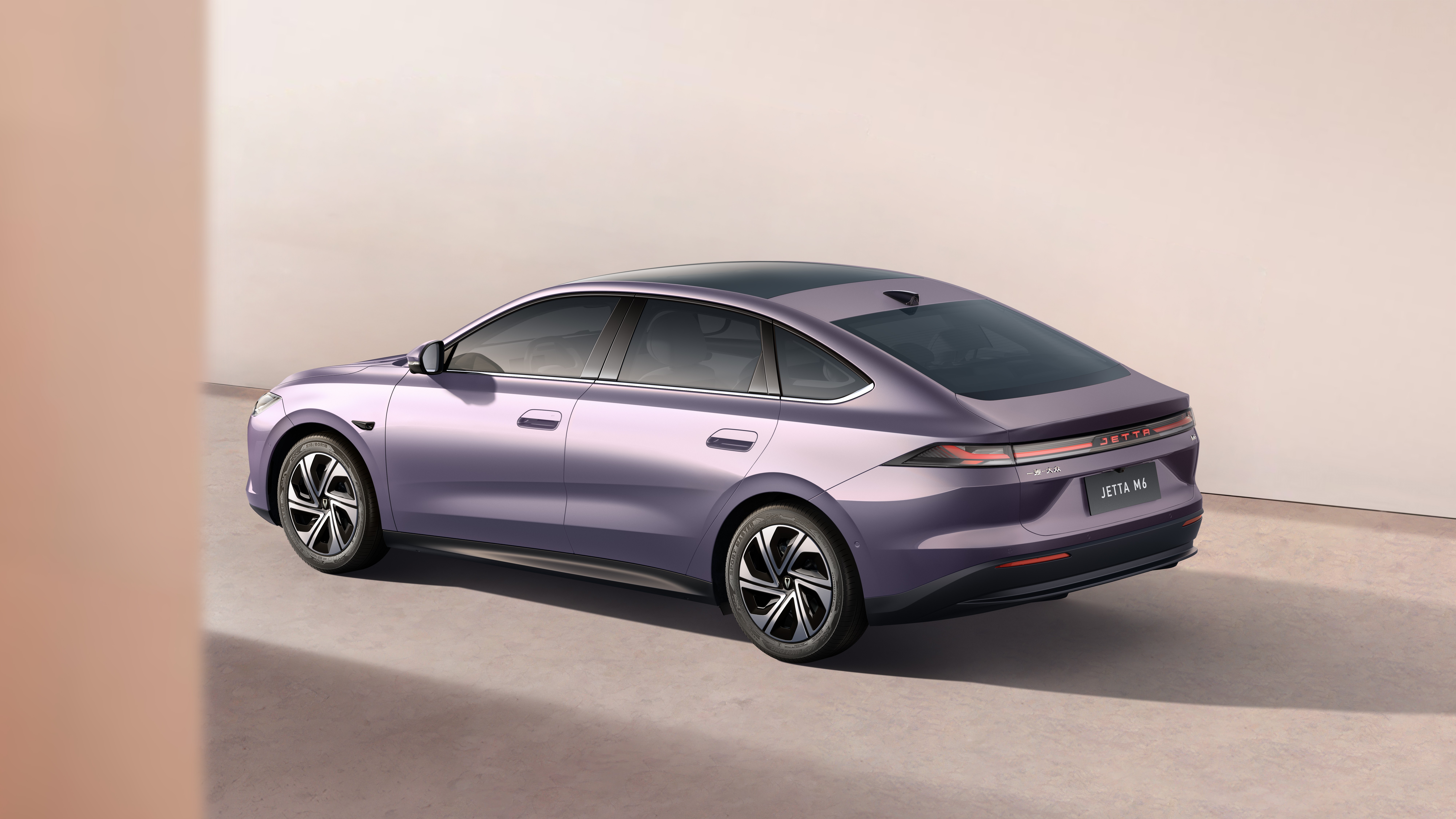 Carro sedan roxo met&aacute;lico, modelo Jetta MA, visto de tr&ecirc;s quartos traseiro, estacionado em um ambiente minimalista com parede clara e ch&atilde;o cinza