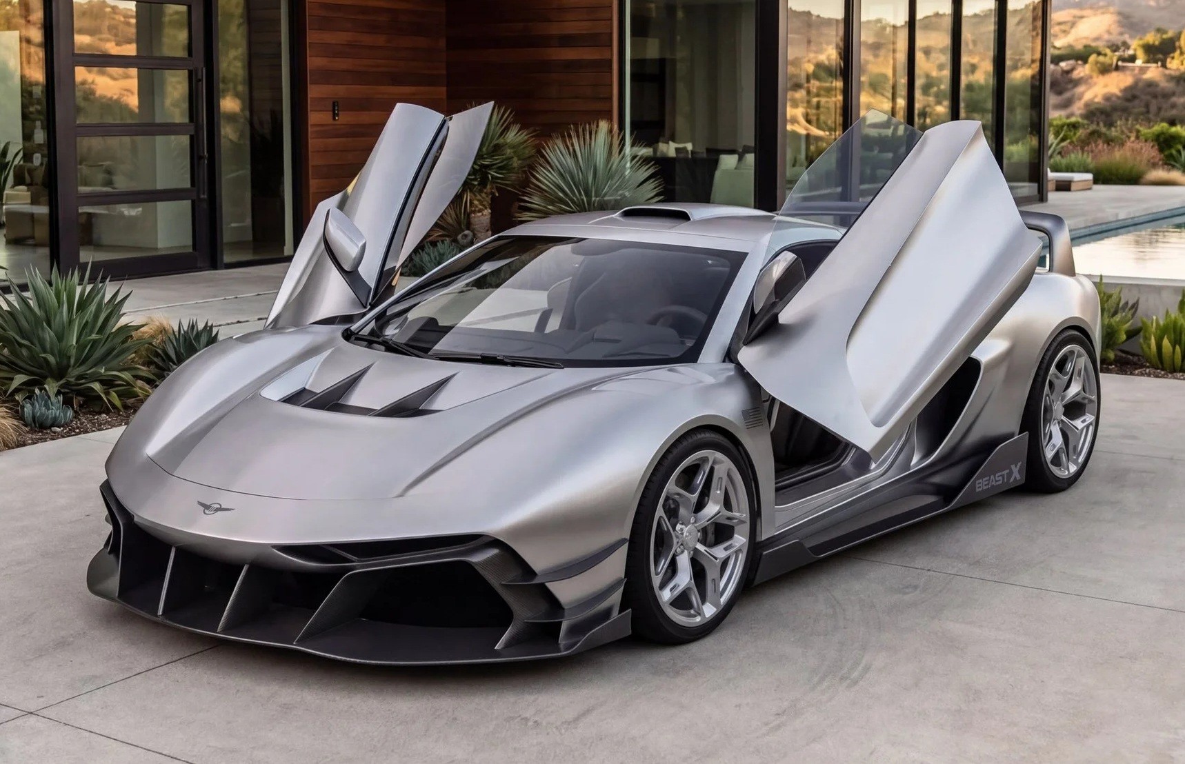 Carro esportivo prateado com portas abertas para cima, estilo asa de gaivota, estacionado em uma &aacute;rea externa com piso de concreto, em frente a uma casa moderna com paredes de madeira e vidro, e plantas suculentas ao redor. Ao fundo, uma piscina e montanhas distantes sob um c&eacute;u claro
