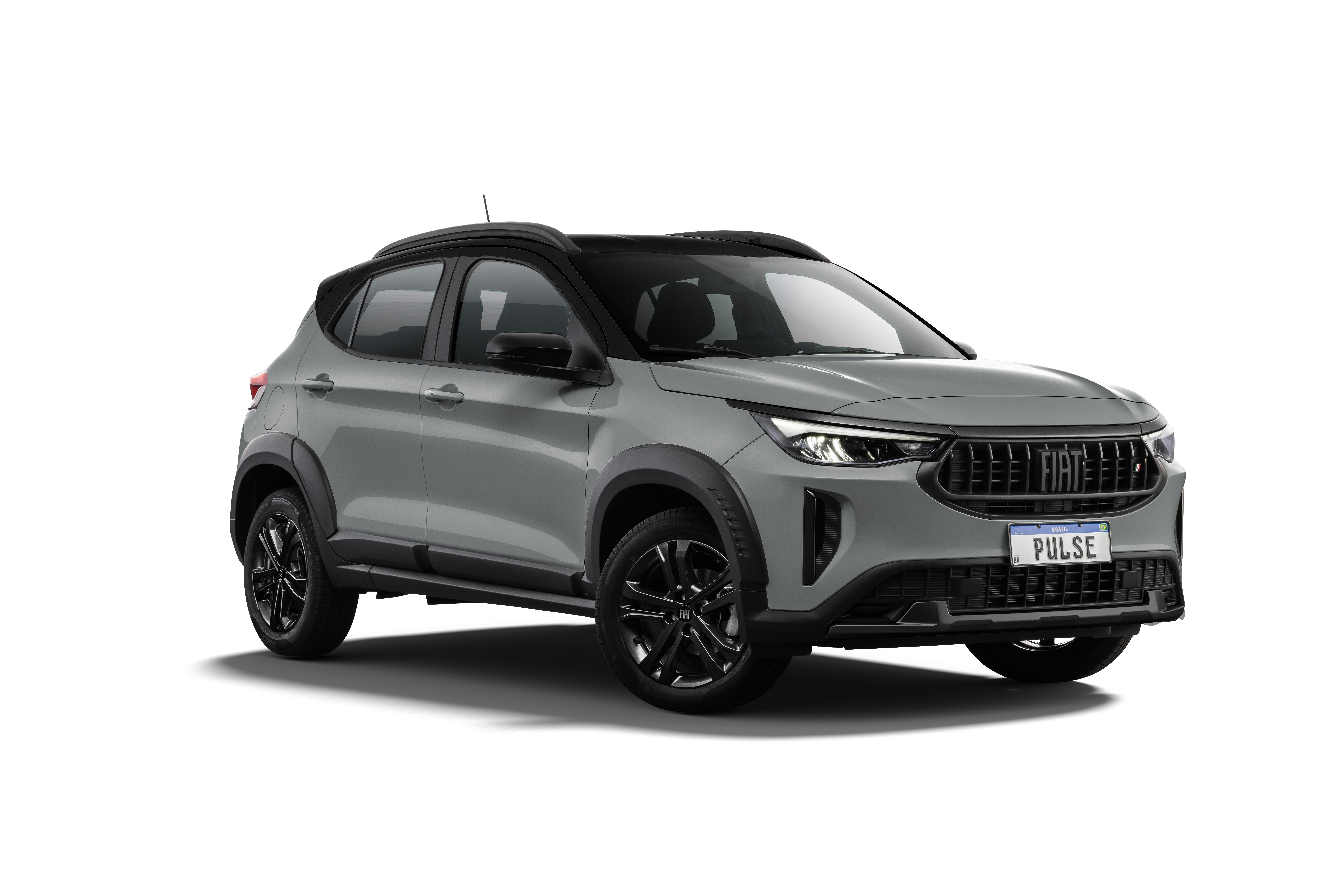 SUV Fiat Pulse cinza claro com teto preto, rodas pretas e detalhes em pl&aacute;stico preto nas caixas de roda e laterais, visto de frente e levemente de lado, com a placa PULSE