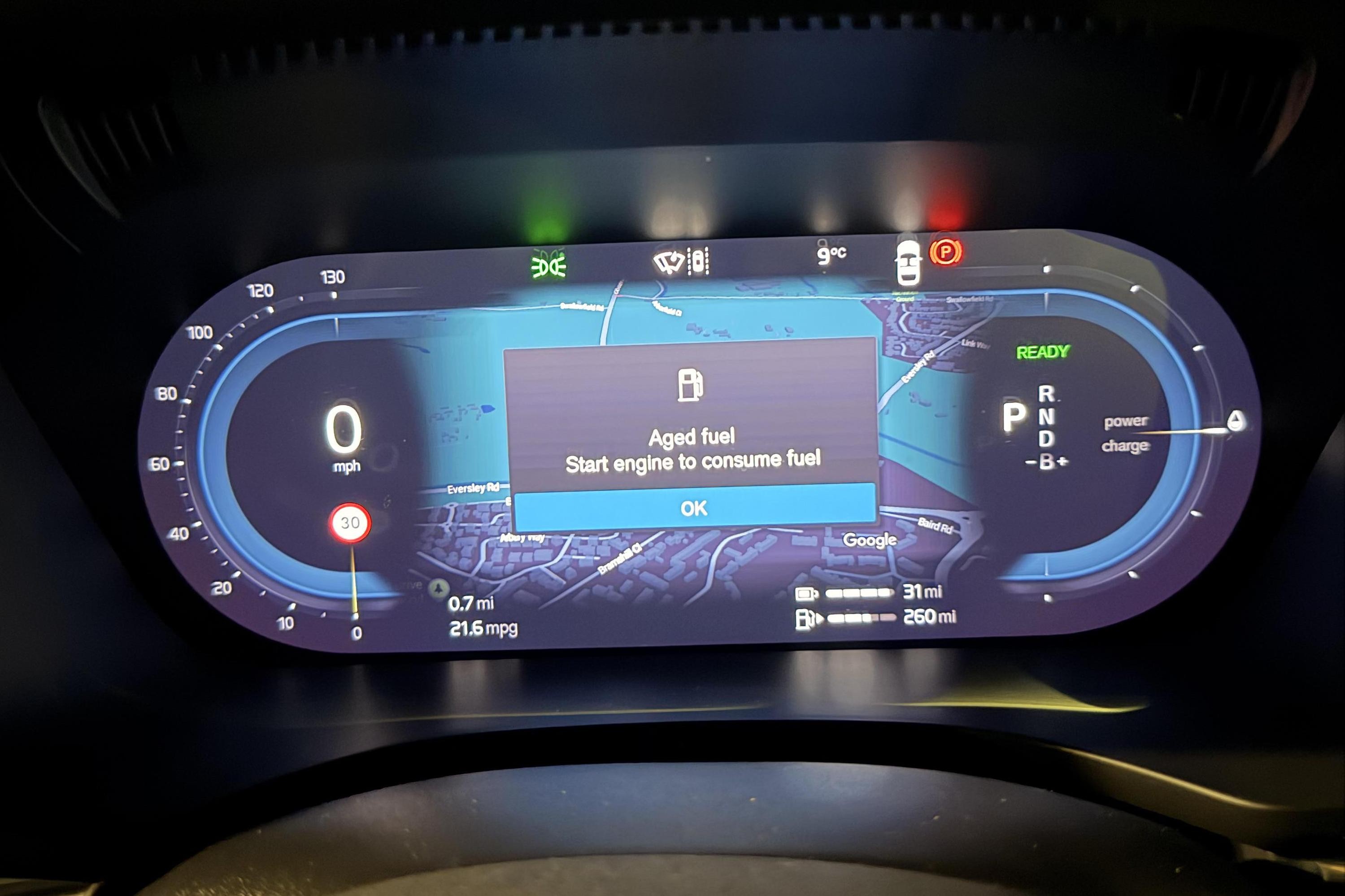 Painel digital de carro com veloc&iacute;metro marcando zero, mapa de navega&ccedil;&atilde;o e aviso Aged fuel. Start engine to consume fuel com bot&atilde;o OK